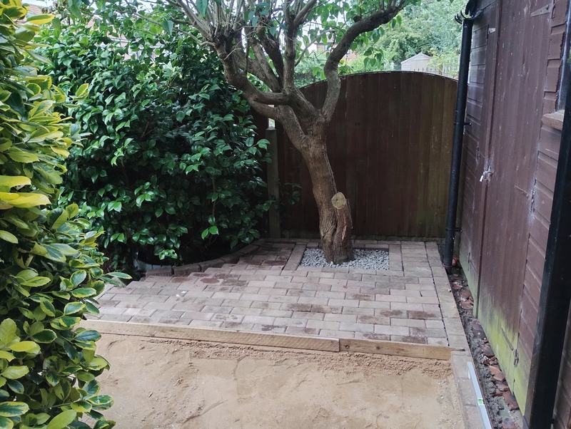 Block paving laid around a tree with a gravel surround, on a sand bed