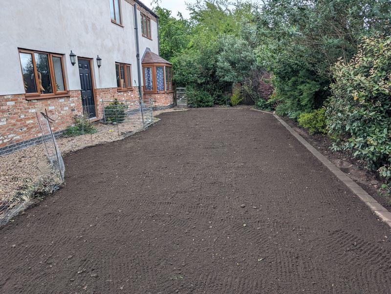 Garden area levelled and raked with fresh topsoil beside the same house