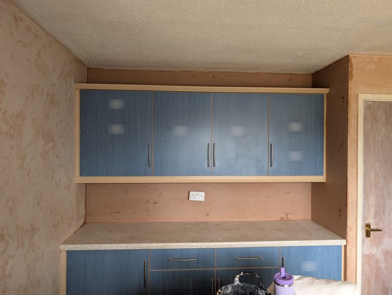 Kitchen wall freshly skim plastered above and behind blue units