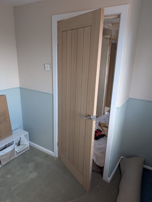 New oak-faced internal door hung in a white frame