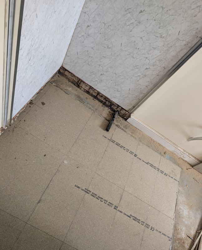 New floor boards laid in a bathroom with a pipe stub ready for the shower